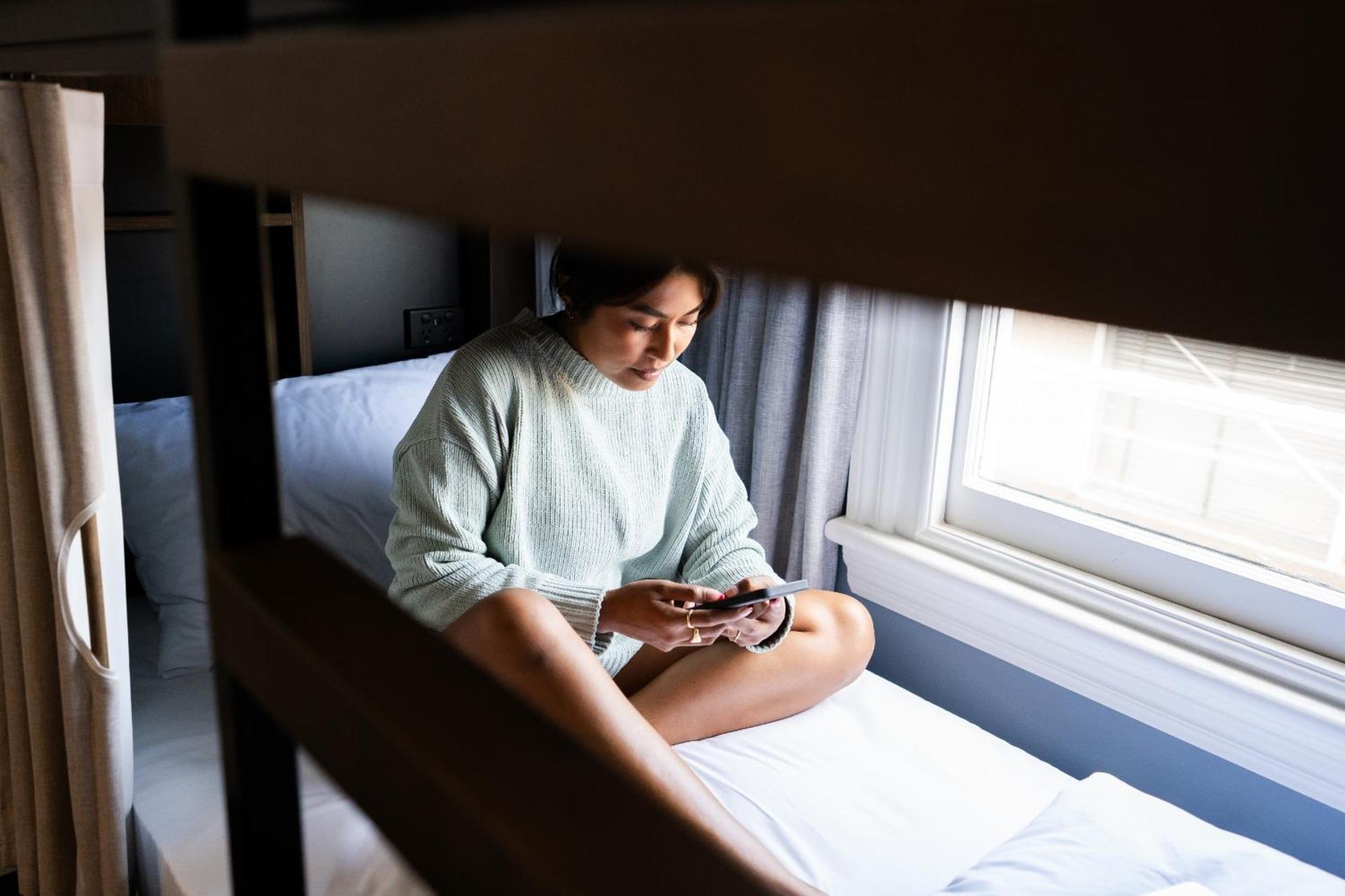 로토루아 Yha 로터루아 호스텔 외부 사진 A woman sitting on a bunk bed